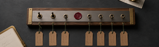 Walnut-and-brass Schaltbrett mit sieben Messing-Kipp-Schaltern auf matt dunklem Schiefer, drei Schalter angehoben, ein einzelner oxblood-Wachssiegel-Akzent zwischen den Reihen — Metapher für sieben Symfony-CVEs, die in einem Wartungsfenster gemeinsam geprüft und bereinigt wurden.