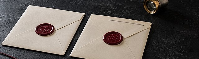 Zwei identisch versiegelte cremefarbene Pergament-Briefumschläge mit oxblutfarbenen Wachssiegeln auf glattem Beton; der rechte Umschlag ist trotz intakten Siegels seitlich aufgeschlitzt und gibt einen abweichenden Briefinhalt frei. Daneben eine messingfarbene Juwelierlupe und ein einzelner oxblutfarbener Baumwollfaden, der aus dem Bild führt, in kühlem Nordlicht.